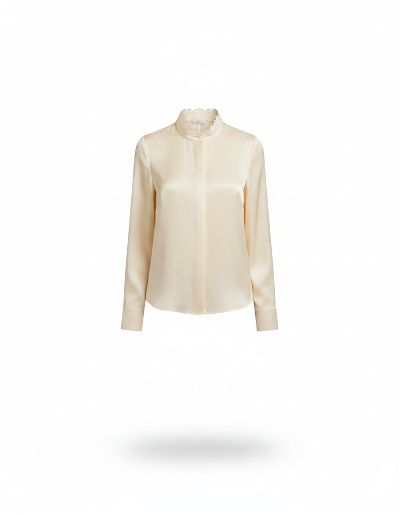 Seidenbluse: Creme, fließend, mit schmaler Spitzenborte am Kragen.
